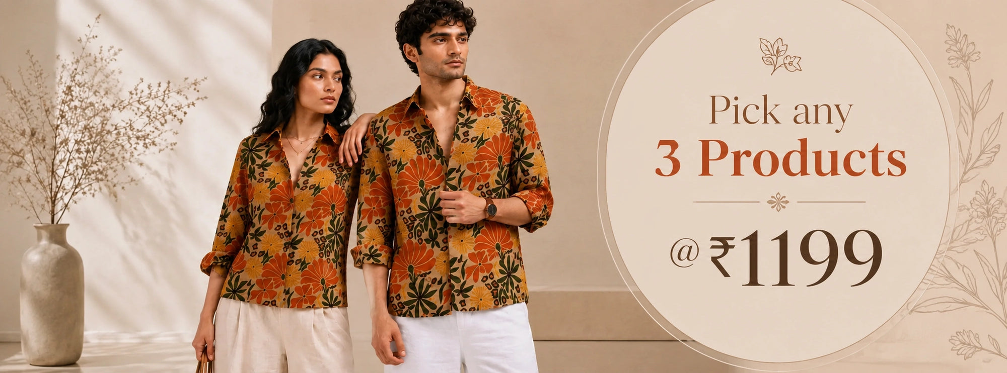 A promotional banner featuring a man and a woman wearing matching orange and black floral patterned button-up shirts, styled with white pants in a warm beige interior setting. A large circular graphic on the right reads 'Pick any 3 Products @ 1199' with decorative floral borders.